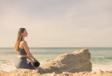 Yoga yapan bir kadın. Güzel kız çevrimiçi sınıfta Asana antrenmanı yapıyor. Sakinleş ve rahatla. Gündoğumlu arkaplan