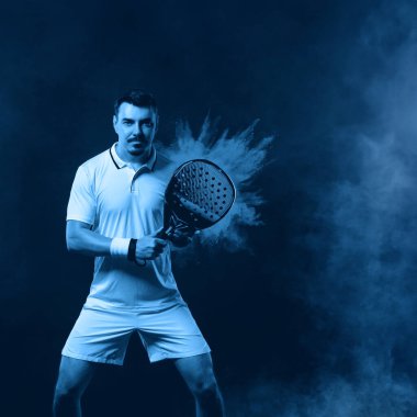 Raketli Padel tenisçi. Sahada raketli, neon renkli bir erkek sporcu. Spor konsepti. Bir spor uygulaması ya da bahis sitesi tasarımı için yüksek kaliteli bir fotoğraf indir