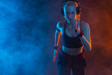 Hızlı koşu. Siyah arka planda koşan güçlü atletik kadın spor kıyafetlerini giyiyor. Spor ve spor motivasyonu. Çalıştırıcı kavramı