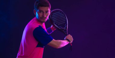 Raketli Padel tenisçi. Sahada raketi neon renkli genç bir sporcu kız. Spor konsepti. Bir spor uygulaması ya da bahis sitesi tasarımı için yüksek kaliteli bir fotoğraf indir