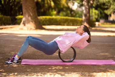Yoga yapan bir kadın. Güzel kız çevrimiçi sınıfta Asana antrenmanı yapıyor. Sakinleş ve rahatla. Parkta yoga eğitimi almış.