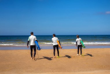 Okyanusta sörf yapmayı öğrenen bir sörfçü. İlk sörf dersi. Amatör sörfçü. Sörf eğitimi. Sosyal medyada sörf okulu reklamı için fotoğraf.
