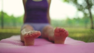 Yoga yapan bir kadın. Güzel kız çevrimiçi sınıfta Asana antrenmanı yapıyor. Sakinleş ve rahatla. Parkta yoga eğitimi almış.