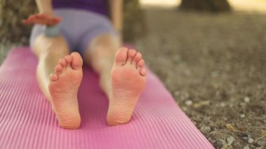 Yoga yapan bir kadın. Güzel kız çevrimiçi sınıfta Asana antrenmanı yapıyor. Sakinleş ve rahatla. Parkta yoga eğitimi almış.