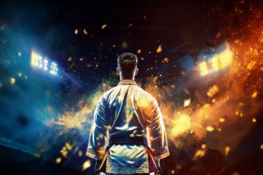 Geleneksel kimono giymiş genç adam karate ve tekvando hareketleri yapıyor. Siyah kuşak. Spor kavramı siyah arkaplanda izole edildi.