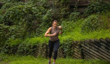 Ormanda koşan aktif bir kadın. Gezgin doğanın tadını çıkarıyor. Yürüyüş kavramı, aktif yaşam tarzı. Maceralar