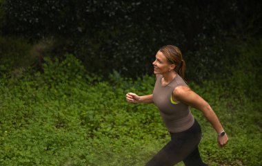 Ormanda koşan aktif bir kadın. Gezgin doğanın tadını çıkarıyor. Yürüyüş kavramı, aktif yaşam tarzı. Maceralar