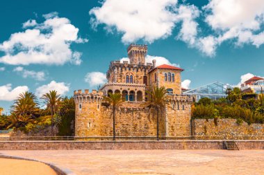 Estoril tren istasyonu ve Tamariz plajı yakınlarındaki zarif Palacio Estoril Oteli, seyahat rehberleri ve kartpostallar için mükemmel tarihi deniz kenarı simgesi.