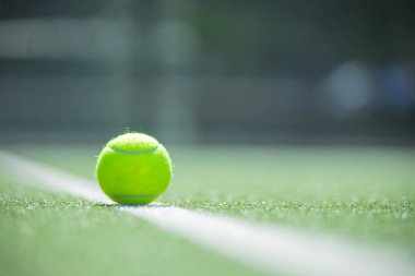 Sentetik yüzeyde duran sarı padel topunun yakın çekimi, padel turnuvaları, kulüpler veya fitness reklamları için mükemmel.