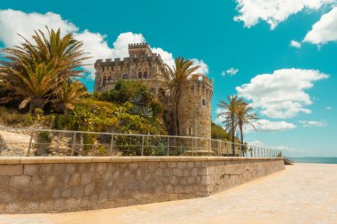 Estoril tren istasyonu ve Tamariz plajı yakınlarındaki zarif Palacio Estoril Oteli, seyahat rehberleri ve kartpostallar için mükemmel tarihi deniz kenarı simgesi.