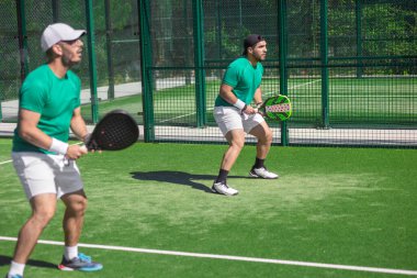 İki padel oyuncusu. Sosyal medya iletileri ve spor reklamları için ideal enerjik padel oyunu anı.