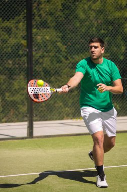 Beyaz arka planda raketi olan Padel oyuncusu, Padel raket, top, spor giyim, e-ticaret afişleri, sosyal medya promosyonları satan reklamlar için fotoğraf