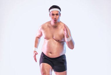 Kilo vermek ve forma girmek için koşan şişman bir adam. Şişman adam spor ve sağlık seyahatinin bir parçası olarak dışarıda antrenman yapıyor. Egzersiz yoluyla yaşam tarzını değiştirmek için gerçek çaba