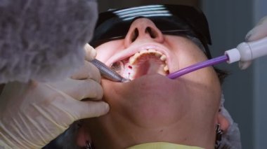 Ağız cerrahı diş implantı açmak için yaşlı kadın sakızında delik açıyor. Modern diş sağlığı kliniğinde asistanı olan bir diş hekimi.