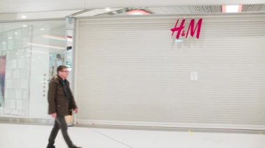 SAINT-PETERSBURG, RUSSIA - MARCH 30, 2022: Sanctions in Russia. Closed H and M store in Russian shopping mall due to armed conflict in Ukraine. Customers walking by the locked doors.