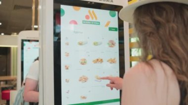 SAINT-PETERSBURG, RUSSIA - JUNE 29, 2022: woman ordering food at fast food restaurant Vkusno I Tochka, which are reopened clones of McDonalds who left Russia after sanctions were imposed.