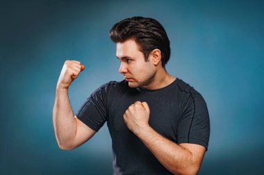Young brunette man fighter on blue background