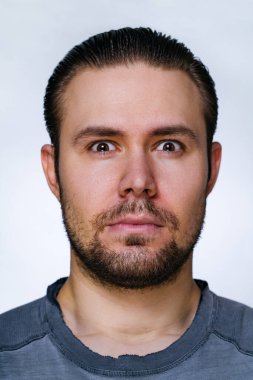Young serious man with beard portrait on white background