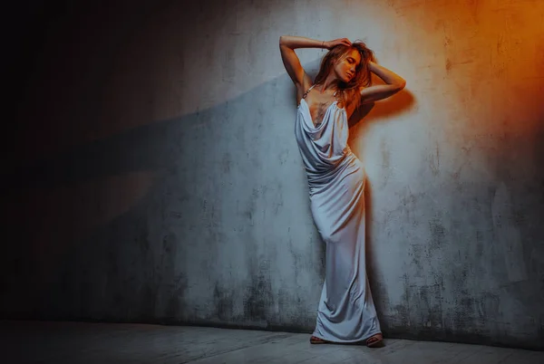 Beyaz Elbiseli Genç Bir Kadın Duvar Arkasında Poz Veriyor Vücudunda — Stok fotoğraf