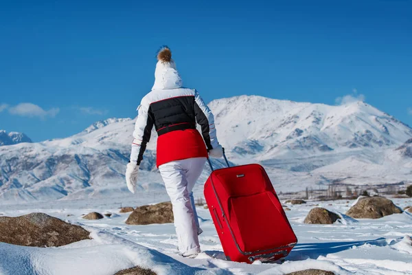 Genç Bir Kadın Kışın Dağlarda Kırmızı Bavulla Seyahat Ediyor — Stok fotoğraf