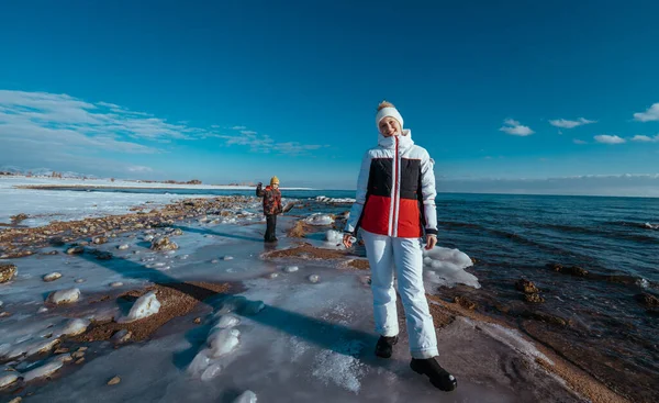 งสาวท กเด นบนชายฝ งทะเลสาบในสภาพอากาศฤด หนาวท แดด — ภาพถ่ายสต็อก