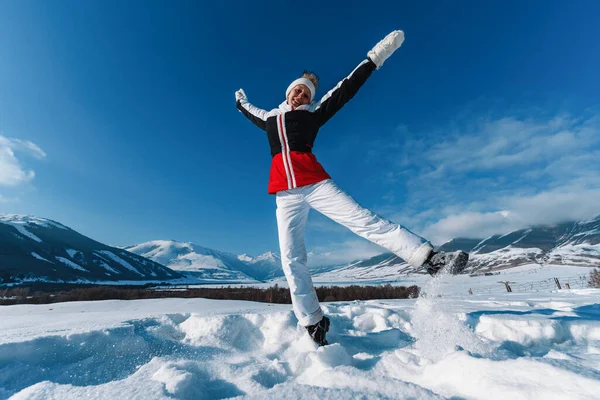 年轻快乐的女人在冬季跳山的背景 — 图库照片