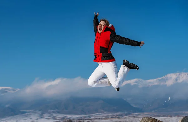 Νεαρή Ευτυχισμένη Γυναίκα Πηδώντας Βουνά Φόντο Κατά Χειμερινή Περίοδο — Φωτογραφία Αρχείου