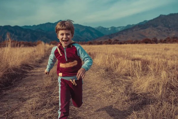 Παιδί Που Τρέχει Στο Πεδίο Του Φθινοπώρου Στο Φόντο Βουνά — Φωτογραφία Αρχείου