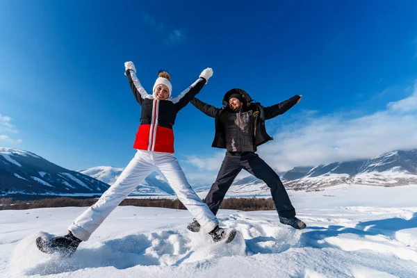 Jovem Homem Mulher Feliz Pulando Fundo Das Montanhas Temporada Inverno — Fotografia de Stock