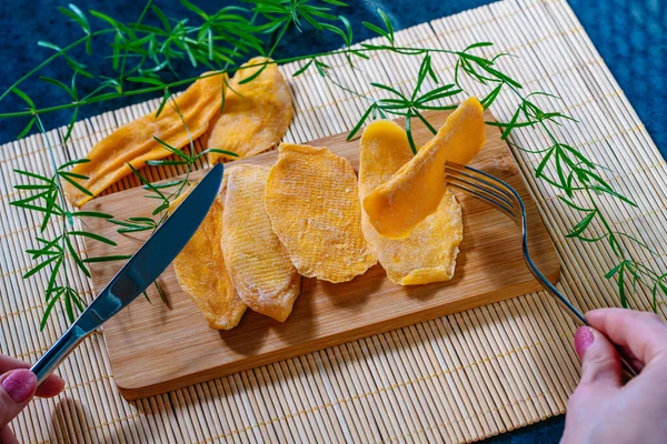 Üzerinde Kurumuş Mango Olan Mutfak Masası Çatal Bıçak Tutan Kadın — Stok fotoğraf