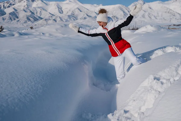 年轻的女游客在冬山的背景下滑落在厚厚的积雪中 — 图库照片