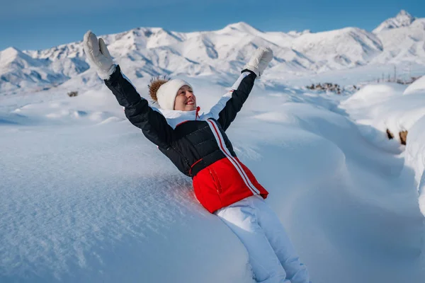 年轻快乐的女性游客在冬山的背景下在大雪中坠落 — 图库照片