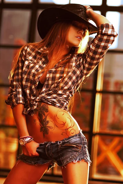 年轻女子牛仔在夕阳下 身上有纹身 — 图库照片