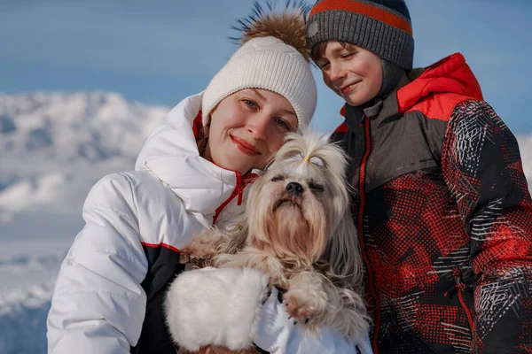 Mother, son and shih tzu dog on winter mountains background