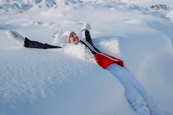 年轻快乐的女性游客在冬山的背景下在大雪中坠落 — 图库照片