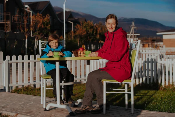 母亲和儿子在乡间房子的院子里喝茶 — 图库照片