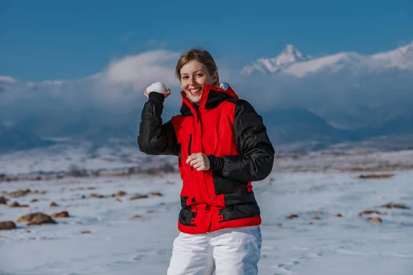 Νεαρή Γυναίκα Ρίχνει Μια Χιονόμπαλα Στο Φόντο Του Βουνού — Φωτογραφία Αρχείου