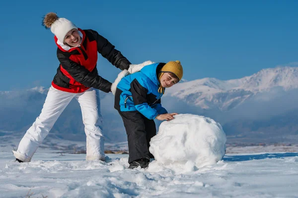 Счастливые Мама Сын Делают Снеговика Горах — стоковое фото