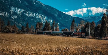 Sonbaharda dağlarda yük taşıyan tren lokomotifi