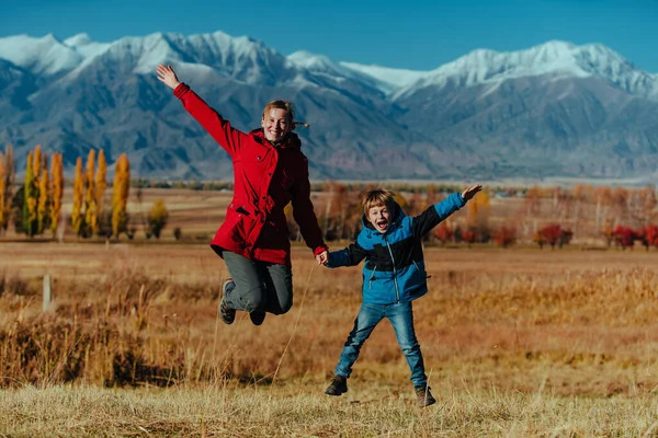 Счастливая Женщина Ребенок Прыгают Фоне Гор Осенью — стоковое фото