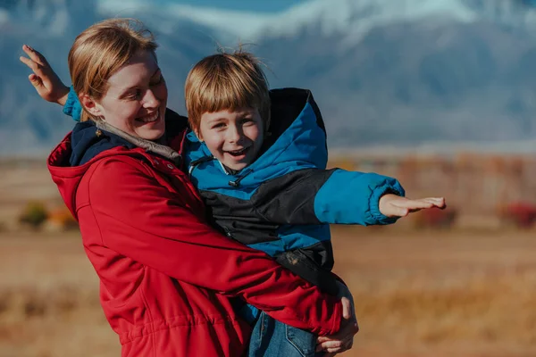山を背景に息子と幸せな若い女性の肖像画 — ストック写真