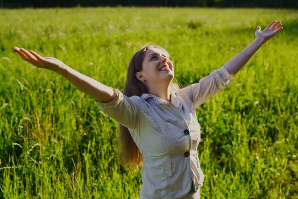 快乐的年轻女子在夏天的田野里张开双臂 — 图库照片