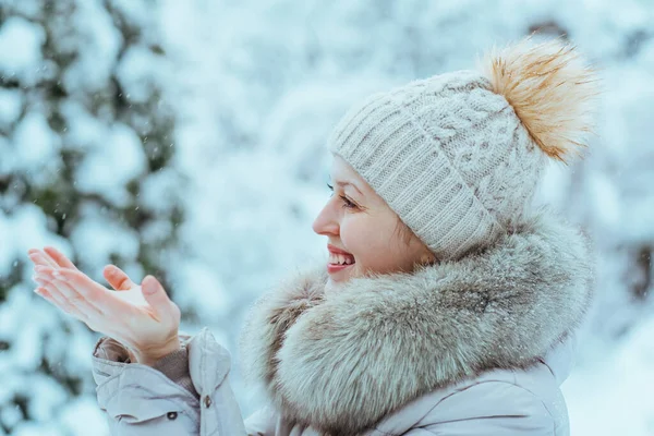 年轻快乐的女人穿着温暖的冬衣 捕捉雪花 — 图库照片