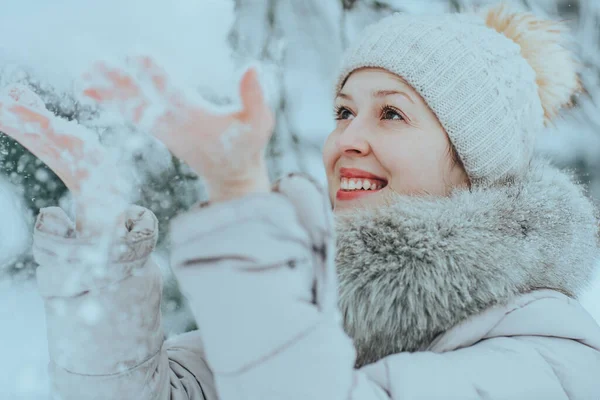年轻快乐的女人穿着温暖的冬衣 吐着雪 — 图库照片