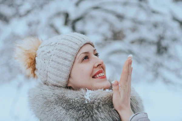 若いです幸せな女性で暖かい冬服キャッチ雪の結晶 — ストック写真