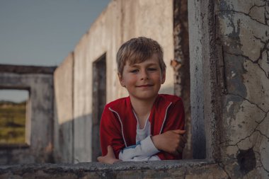 Yıkılmış bir binada sevimli bir çocuğun portresi.