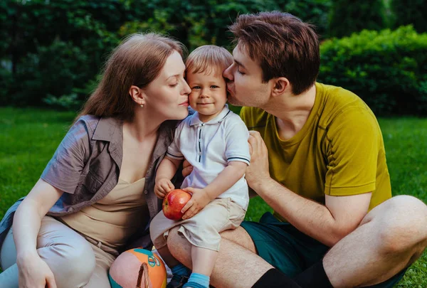 Young Parents Kissing One Year Child Outdoors — Stock Photo, Image