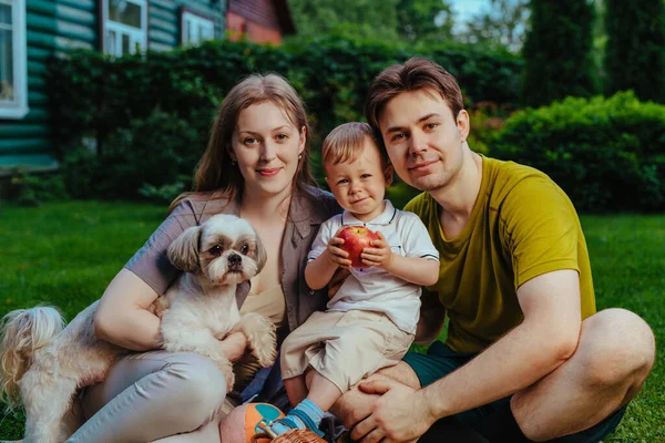 1歳の子供と犬が敷地内に座っている若い両親 — ストック写真