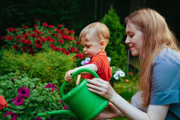 Genç Bir Kadın Bir Yaşındaki Çocuğu Bahçede Çiçek Bakıyorlar — Stok fotoğraf