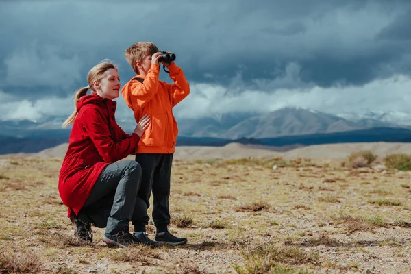 双眼鏡をかけた男の子の観光客と山の中で彼の母親 — ストック写真